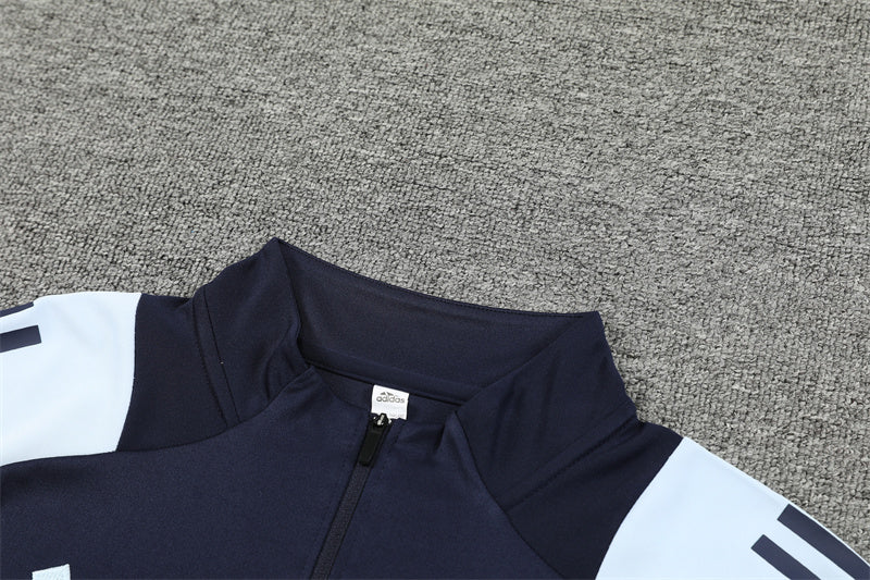 Chándal Oficial Real Madrid 24/25 - Edición Azul Marino con Detalles en Blanco y Naranja